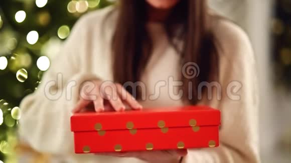 无法辨认的布鲁内特打开圣诞礼物印度打开红色盒子与礼物模糊的圣诞夜视频的预览图