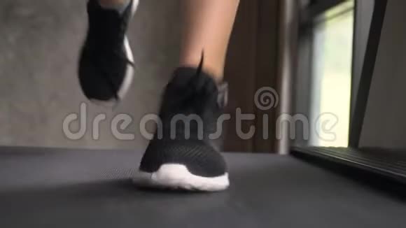 年轻女子在健身房跑步机上用无绑花边慢跑正面向上看视频的预览图