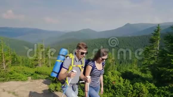 一对年轻夫妇正走在山路上在风景如画的山林中视频的预览图