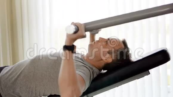 有决心的运动青年穿着灰色t恤在健身房锻炼举重机视频的预览图