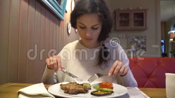 在餐厅享用烤牛排的女人视频的预览图