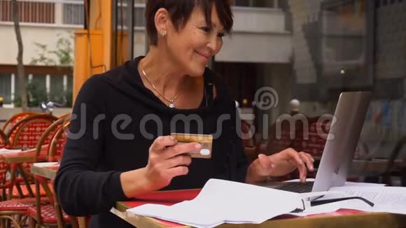 协同工作中心的慢动作女性客户通过信用卡在互联网上用笔记本电脑进行购买视频的预览图