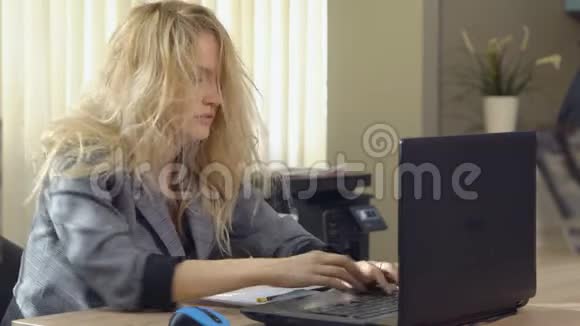 穿西装的疲惫的女商人在办公室的电脑里工作视频的预览图