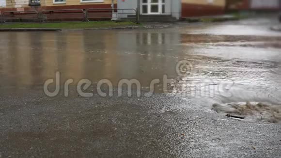 雨水落在道路上流经下水道排水沟汽车在洪水中行驶视频的预览图