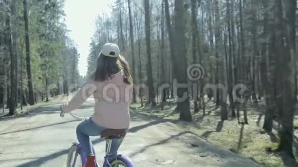女孩骑着一辆老式自行车在森林路上视频的预览图