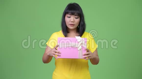 美丽幸福的亚洲女人拿着礼盒一脸惊讶视频的预览图