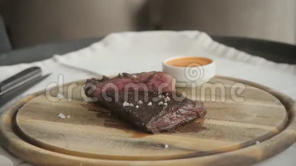 用胡椒和盐调味在烤盘上烤牛排在厨房里煮牛排新鲜美味辛辣多汁视频的预览图