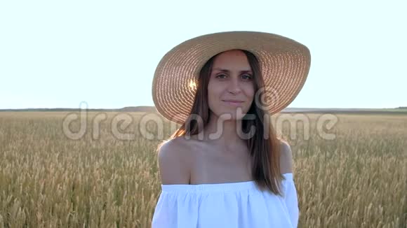 美丽的女人站在成熟的金麦地上的惊人画像视频的预览图