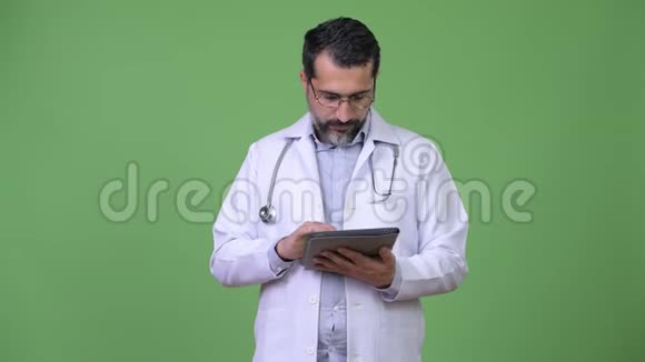 英俊的波斯胡子男医生在使用数码平板电脑时思考视频的预览图