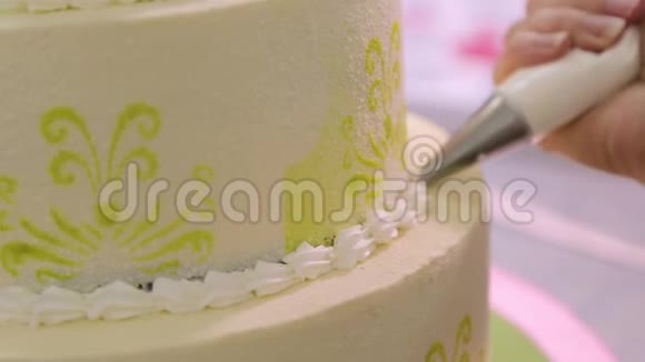糕点店里用奶油做蛋糕装饰女人手视频的预览图