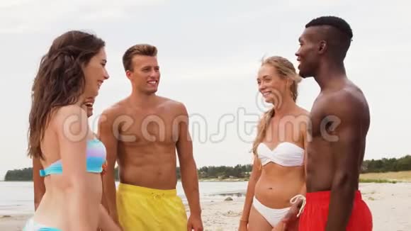 快乐的朋友在夏天的沙滩上叠手视频的预览图