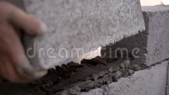一个建筑工人在工地上工作并砌墙的特写镜头视频的预览图