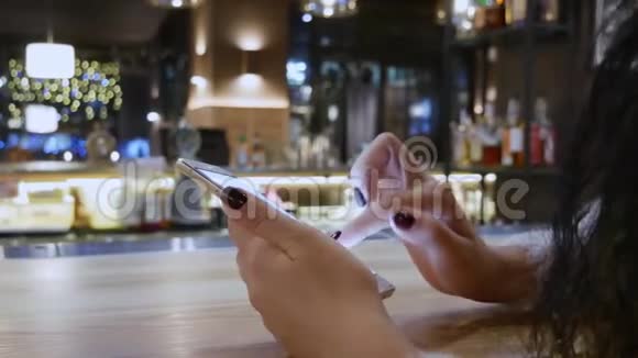 把手举起来餐厅智能手机上的女孩视频的预览图