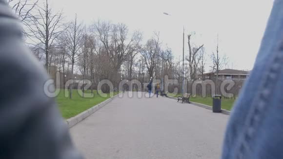 年轻漂亮的夫妇正在公园里散步牵着手他们从摄像机里出来的慢动作视频的预览图
