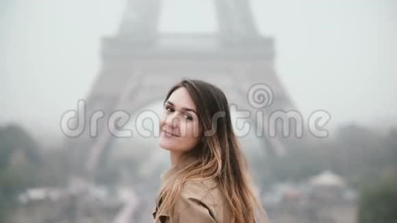 站在法国巴黎埃菲尔铁塔旁的年轻美女转身看着镜头微笑着视频的预览图