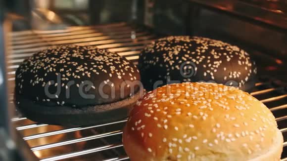 热的汉堡包卷与种子在烤箱中以4k分辨率慢速烘烤视频的预览图