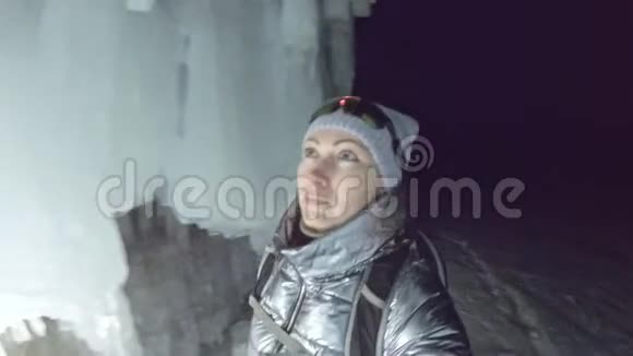 在贝加尔湖冰洞旅行的女人Pov查看自拍女孩背包客正在冰窟散步旅行者看着视频的预览图