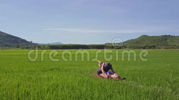 Flycam在女孩周围移动在山上的天空上做瑜伽姿势视频的预览图