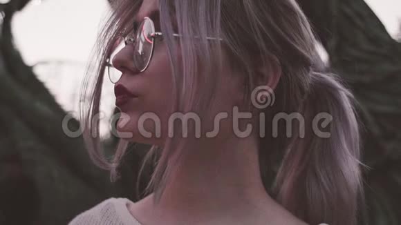 戴眼镜的漂亮少女在闪烁的灯光下摆着肖像视频的预览图