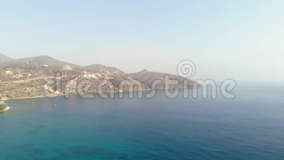 希腊岛屿海岸有清澈的蓝色海洋岩石在水面上在夏天空中观景4K视频的预览图
