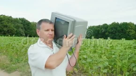 一个严肃的人拖着一台不必要的旧电视在他的肩上视频的预览图