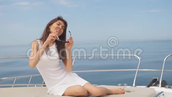 深色头发的女性在帆船上的海洋背景上摆姿势的肖像视频的预览图