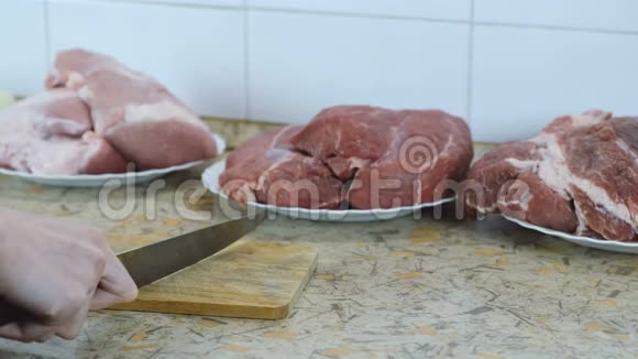 在切割板上用刀把女人的手收起来三个盘子背景上有肉片视频的预览图