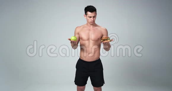 一个男性健身模特对汉堡说不对苹果说是它健康选择健康4k视频的预览图