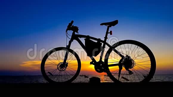 夕阳西下的天空在海上随着自行车的轮廓视频的预览图