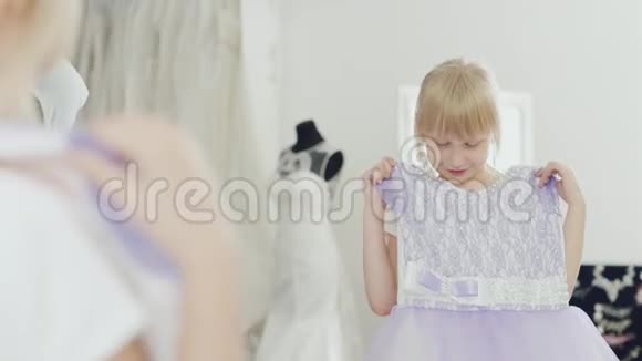 金发女孩6岁看着她的新优雅的裙子看到镜子里的倒影视频的预览图