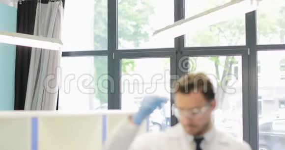 现代实验室试验结果中男性科学家对试管中液体的分析研究视频的预览图