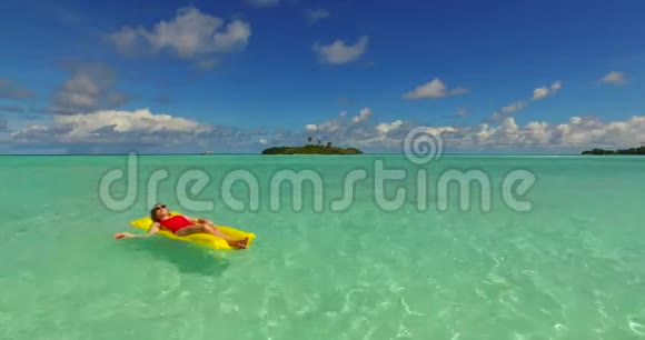 马尔代夫白色沙滩2男青年夫妇在充气床垫上漂浮游泳视频的预览图