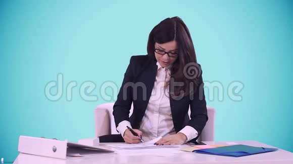 商业女性的肖像布鲁内特戴着眼镜坐在办公室里在员工带来的文件上签名视频的预览图