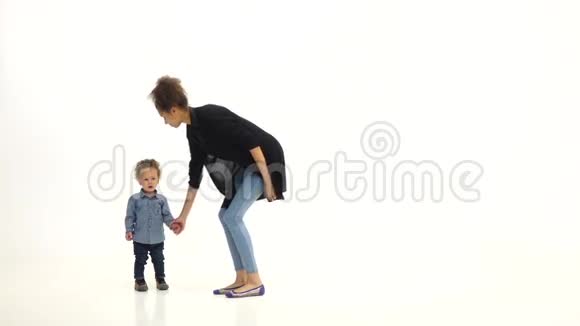 孩子握着母亲手和她跳舞白色背景慢动作视频的预览图