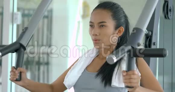 亚洲女孩健身器在健身房里使用举重机视频的预览图