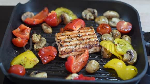 烤架上有鲑鱼和蔬菜烤制方形三文鱼红椒和黄椒樱桃番茄和蘑菇视频的预览图