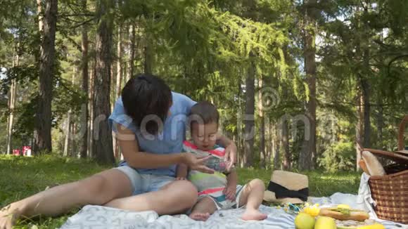 母亲和孩子在公园野餐时吃浆果视频的预览图