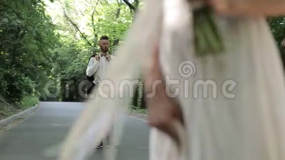 浪漫的婚礼时刻新娘和新郎在日落时分入住公园视频的预览图