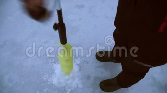 垂钓者在冰冻的河流上钻了个洞视频的预览图