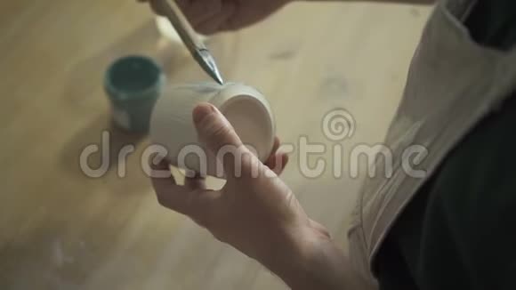男艺术家站在室内的桌子旁画杯子视频的预览图