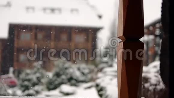 冬天背景模糊大雪期间山村的木制小屋与针叶常绿景观视频的预览图