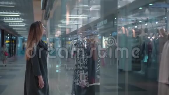 年轻时尚的女士在商店橱窗附近挑选衣服视频的预览图