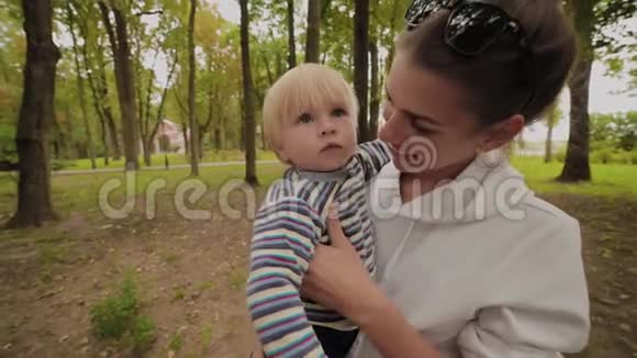 快乐的妈妈和她的儿子在公园里散步视频的预览图