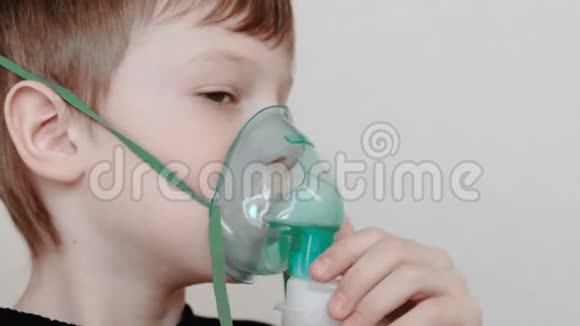 使用雾化器和吸入器进行治疗男孩通过吸入器面罩吸入前景视频的预览图