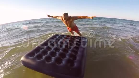 有趣的年轻游客在沙滩上跳在充气床垫上慢动作高清1920x1080克里米亚俄罗斯视频的预览图