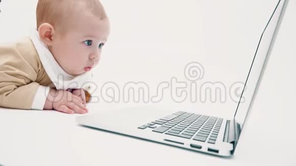 可爱的宝宝在笔记本电脑屏幕上看视频的预览图