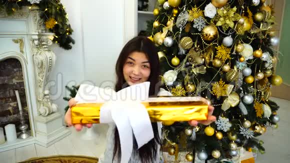 心情愉快的女孩礼物在手相机微笑坐在圣诞背景视频的预览图