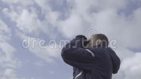 年轻的游客通过望远镜看天空云背景视频的预览图
