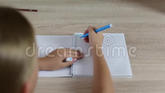 女孩在笔记本上写回学校拼写错误坐在桌子旁的年轻女孩白人女孩写信视频的预览图