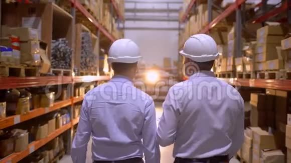 员工男仓库工人安全帽工程师在物流中心工厂施工现场工作两名视频的预览图